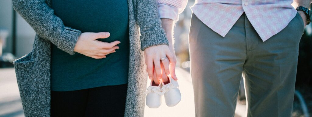 Couple enceinte mains chaussons bébé